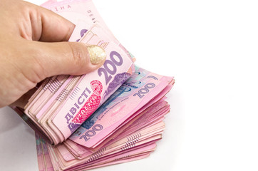 hand counts hryvnia in money stack on a white background. Close-up.Copy space.