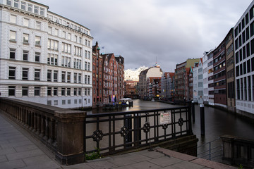Fototapeta premium view of the elbphilharmonie Concert Hall in hamburg with water in the foreground under cloudy skies as a tourist attraction