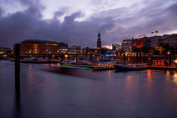 Fototapeta premium view over the elbe to the city panorama of hamburg in the evening light with illumination