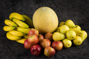 fruits cabbage banana melon grape orange apples pear a dark background. health vegetarianism
