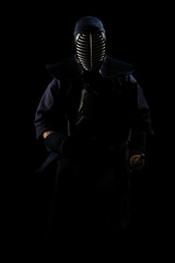 Naklejka premium male in tradition kendo armor with shinai (bamboo sword). shot in studio. Isolated with clipping path on black background