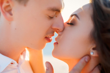 Newlyweds kisses in the desert at sunset