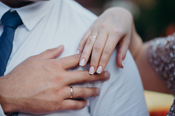 hands of man and woman with wedding rings. Wedding day. Gold rings on the hands of the newlyweds.