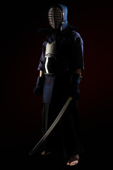 Male in tradition kendo armor with Samurai sword katana. shot in studio. Isolated on black background