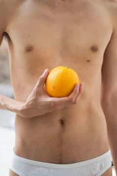 Detalle de joven con naranja