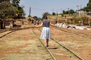 Kobieta idąca po torach na stacji kolejowej w Moshi - obrazy, fototapety, plakaty