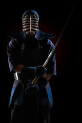 Male in tradition kendo armor with Samurai sword katana. shot in studio. Isolated on black background