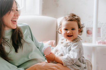 little girl having fun sitting on her mother