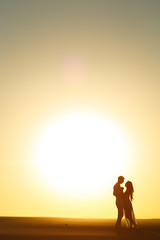 Newlyweds walk barefoot on the sand in the white desert