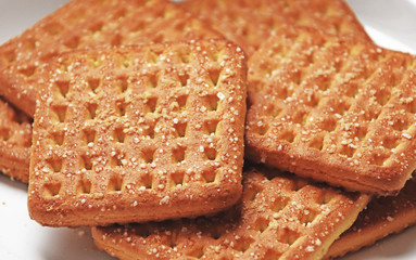 Shortbread brown homemade shortbread from the oven. Cookies are square in shape, flat with a hole, yellow, beige and brown.