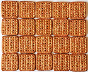 Shortbread brown homemade shortbread from the oven. Cookies are square in shape, flat with a hole, yellow, beige and brown.