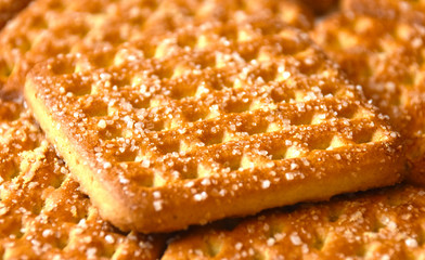 Shortbread brown homemade shortbread from the oven. Cookies are square in shape, flat with a hole, yellow, beige and brown.