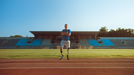 Athletic Disabled Fit Man with Prosthetic Running Blades is Posing with Crossed Arms on an Outdoor...