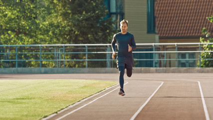 Obraz premium Smiling Athletic Fit Man in Grey Shirt and Shorts Jogging in the Stadium. He is Running Fast on a Warm Summer Afternoon. Athlete Doing His Routine Sports Practice.