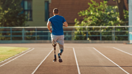 Obraz premium Athletic Disabled Fit Man with Prosthetic Running Blades is Training on a Outdoors Stadium on a Sunny Afternoon. Amputee Runner Jogging on a Stadium Track. Motivational Sports Shot.