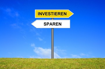 Schild Wegweiser zeigt Investieren oder Sparen