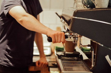 a young man pours coffee in a coffee shop