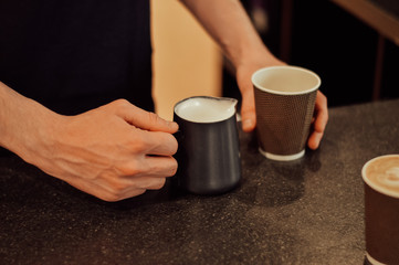 a young man pours coffee in a coffee shop