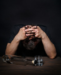 Man with an alcohol addiction sits at a table