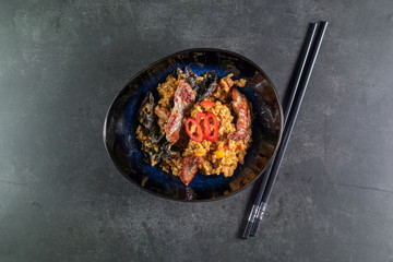beef tahan fried Japanese rice with vegetables and slices of beef in a black plate