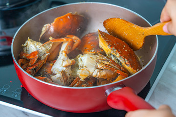 People cooking stir-fried crab with garlic and black pepper