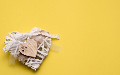 Wooden heart on a yellow background with copy space