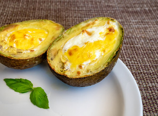Avocado baked  eggs on white plate.