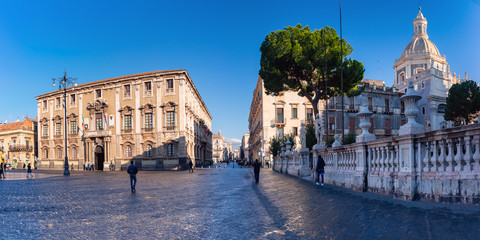 The first sunray on Via Etnea and Piazza Duomo with the Cathedral of Santa Agatha and town hall at...