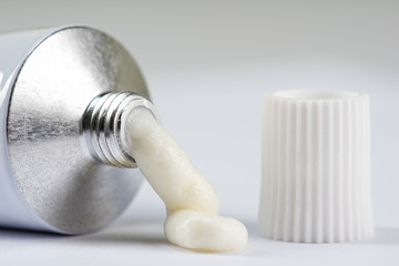 ointment or cream for external use is slightly squeezed out of a tube on a white background on a...