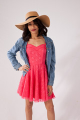 Happy Caucasian woman in a pink sun dress and a straw hat.