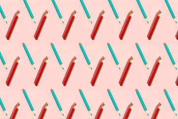 Fototapeta na wymiar Pattern of colorful pencils. Red and blue pencils on pink background. Back to school, education and learning concept. Minimalist isometric concept.