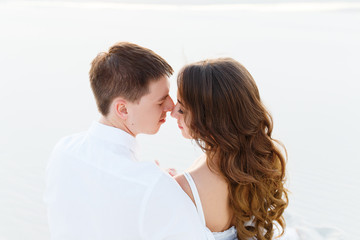 groom hugging bride in the desert at sunset