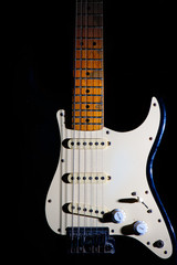 Fototapeta na wymiar Detail of electric guitar on a black background between light or shadows