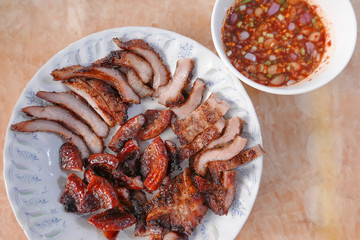 traditional Thai culture fried pork cuisine style or moo tod one of the most favorite famous street fast foods menu at thailand homemade
with hot spicy sauces on table wood dish sticky rice vegetable