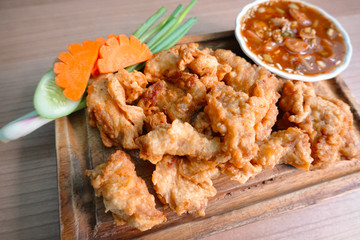 traditional Thai culture fried pork cuisine style or moo tod one of the most favorite famous street fast foods menu at thailand homemade
with hot spicy sauces on table wood dish sticky rice vegetable