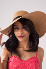 Happy Caucasian woman in a pink sun dress and a straw hat.