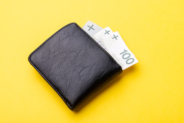 Black leather Men's Wallet with cash on yellow background. From above. copy sapce