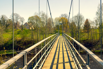 Suspension bridge over the river in spring