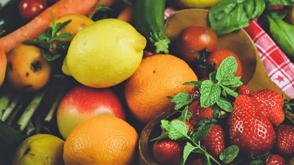 
fruits and vegetables with a bowl with strawberries in the foreground