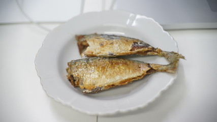 fried fish on white dish on table