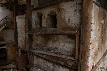Fototapeta na wymiar Interior of an old abandoned village house - brick wood stove