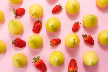 pears and strawberries on a pink background.