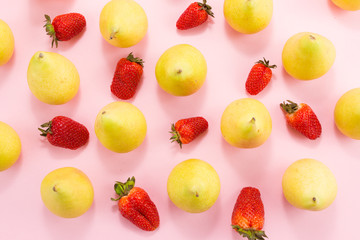 pears and strawberries on a pink background.