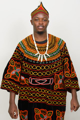 Happy young handsome African man wearing traditional clothing