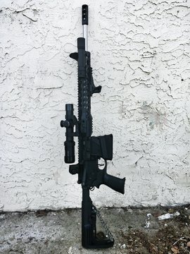 Machine Gun Leaning On White Wall