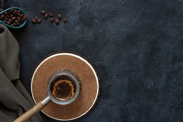 Vintage coffee maker with fresh coffee on a wooden stand on a dark background with coffee beans