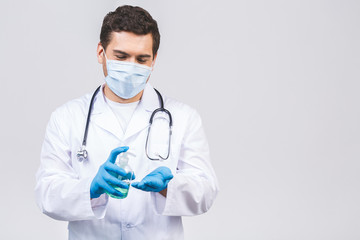 Doctor man in gown face mask gloves isolated on white background. Epidemic pandemic coronavirus 2019-ncov sars covid-19 flu virus. Bottle with alcohol liquid antibacterial sanitizer.