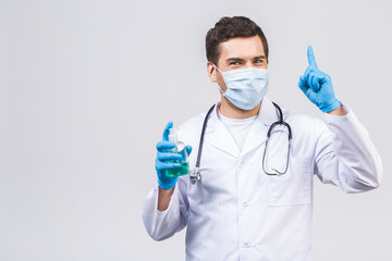 Doctor man in gown face mask gloves isolated on white background. Epidemic pandemic coronavirus 2019-ncov sars covid-19 flu virus. Bottle with alcohol liquid antibacterial sanitizer.