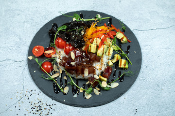 Hawaiian salmon fish poke bowl with rice, radish,cucumber, tomato, sesame seeds and seaweeds. Buddha bowl. Diet food