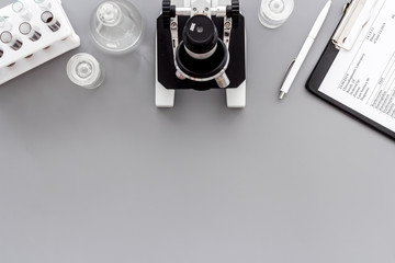 Microscope medical reserch. Blood sample for analysis. Grey table top view copy space